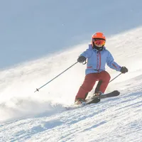 мальчик катится с горы на лыжах