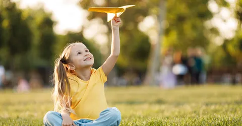 cute-little-girl-with-paper-plane-outdoor