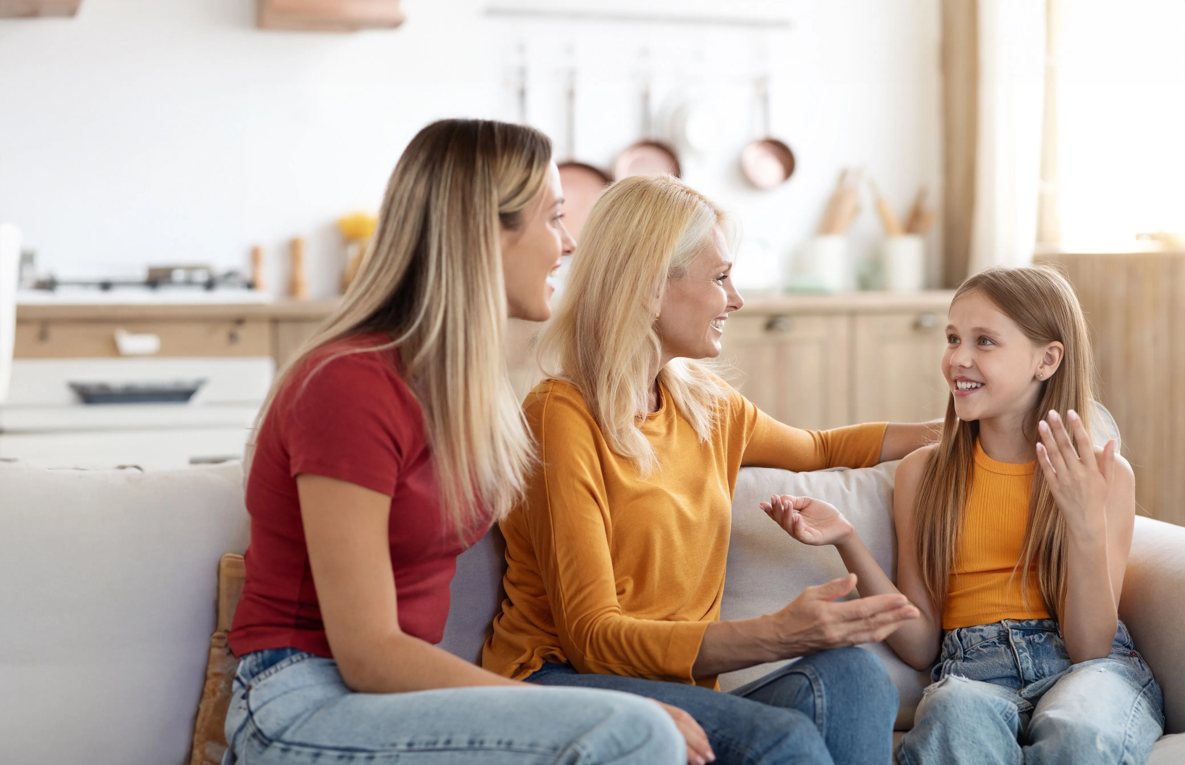 две девушки и девочка сидят на диване