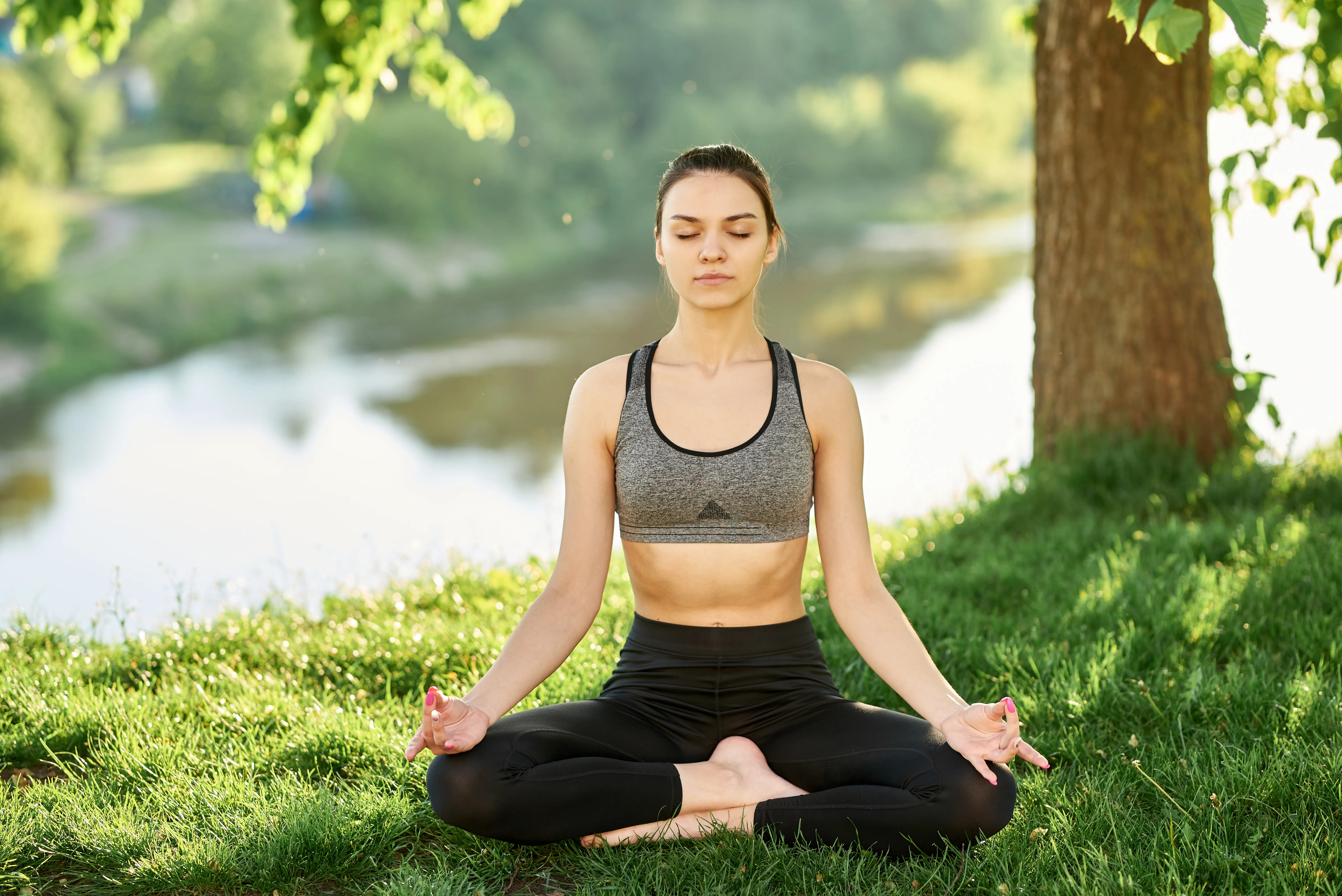 ioga-v-prirode-na-trave-vozle-reki